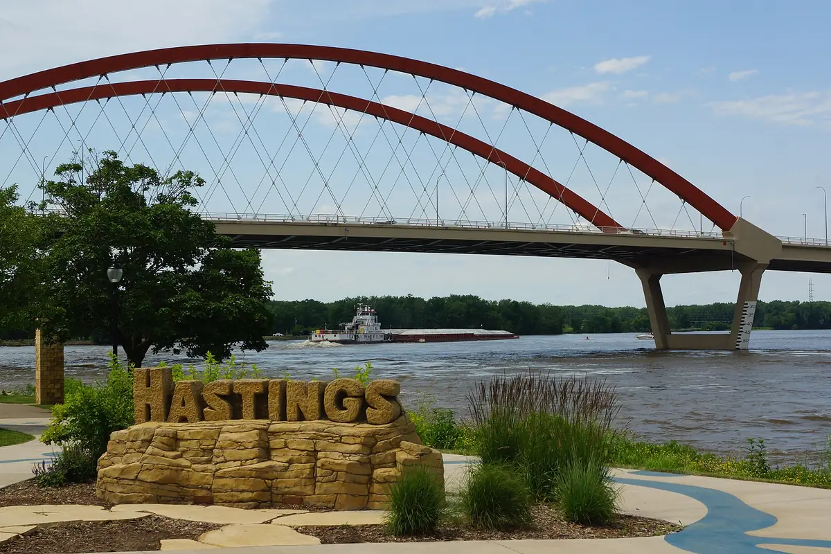 The Hastings sign by the Mississippi River, with the Hastings Bridge behind it
